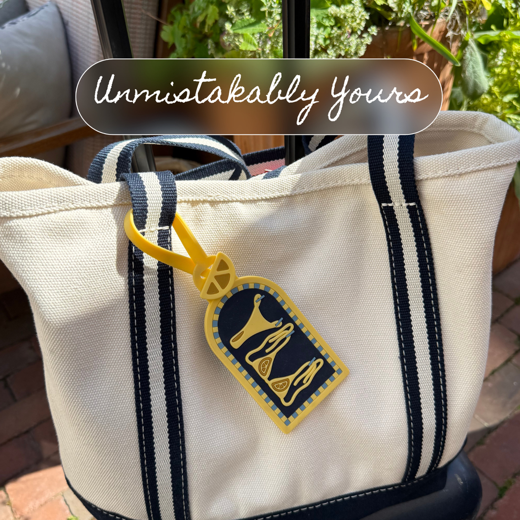 Salty Citrus luggage tag clipped to a navy and cream striped canvas tote bag